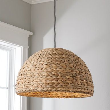 a light fixture hanging from the ceiling in a room with white walls and wood flooring