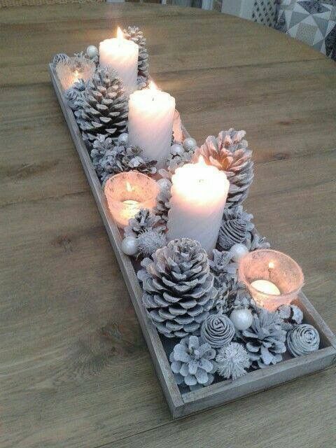 a table with candles and pine cones on it