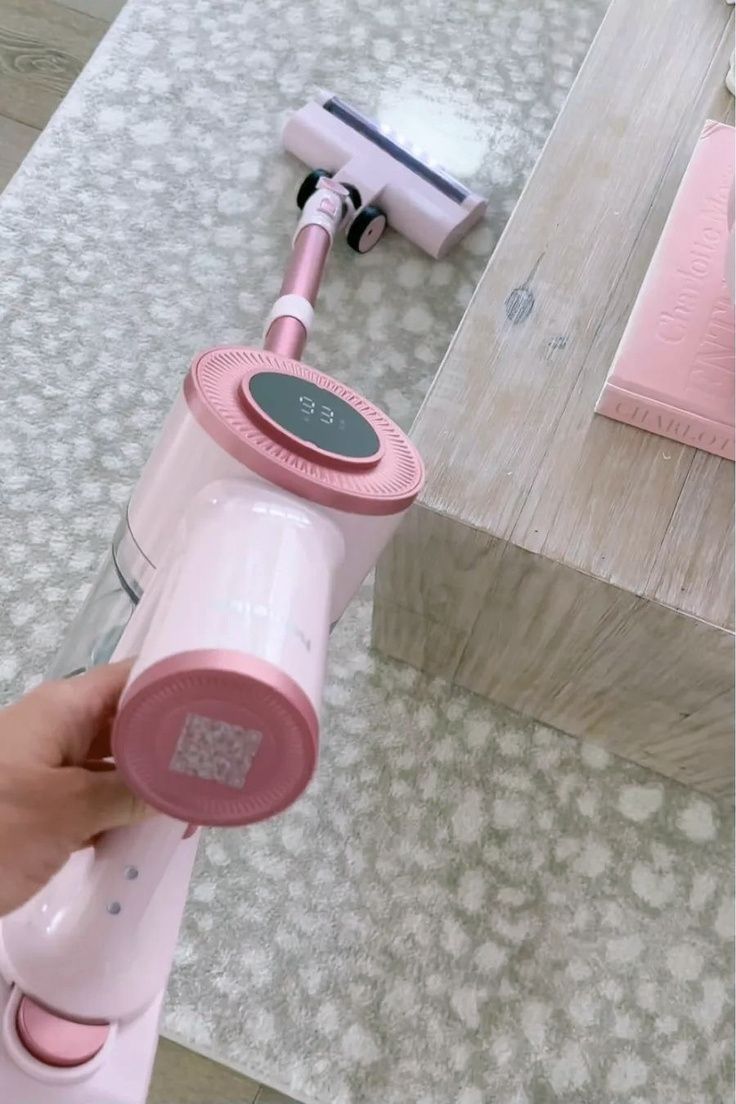 a pink hair dryer sitting on top of a table