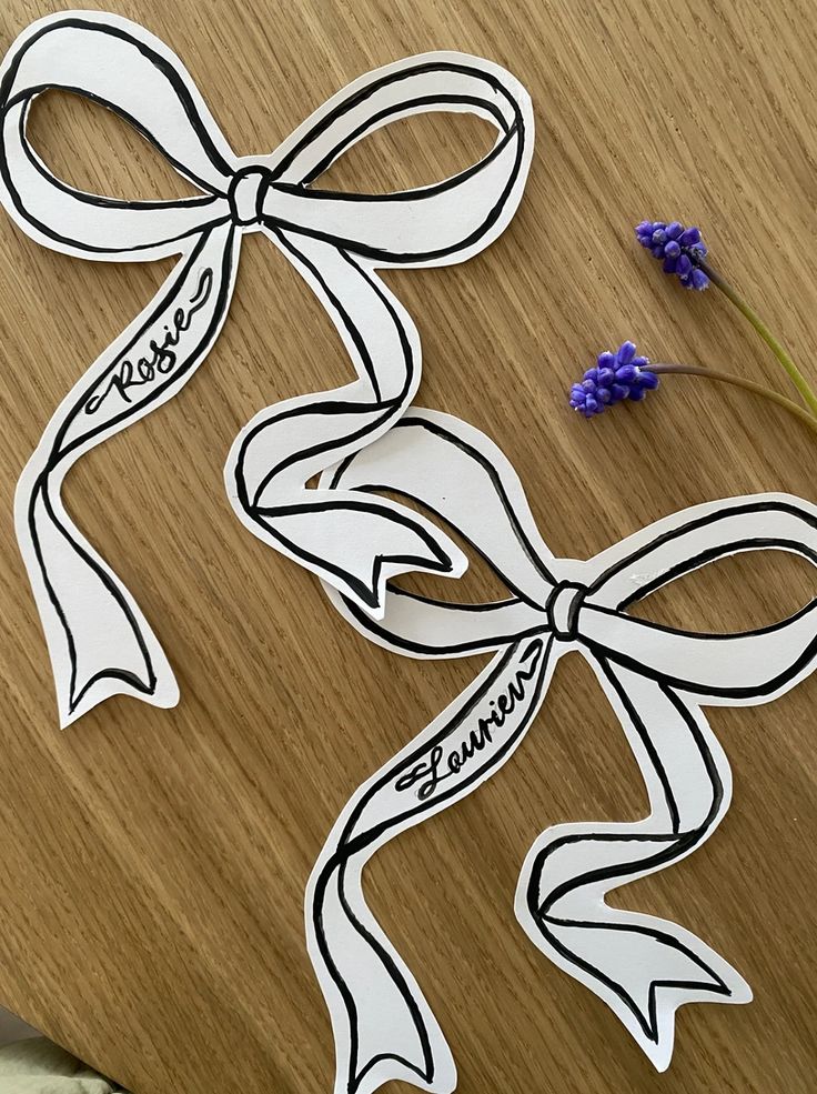 two pieces of paper cut out to look like ribbons