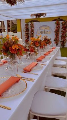 the table is set with orange napkins and place settings for guests to sit at