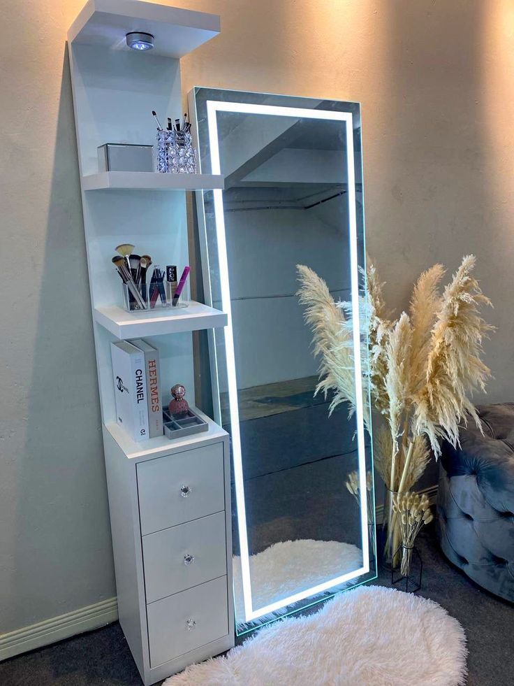 a tall mirror sitting on top of a white shelf