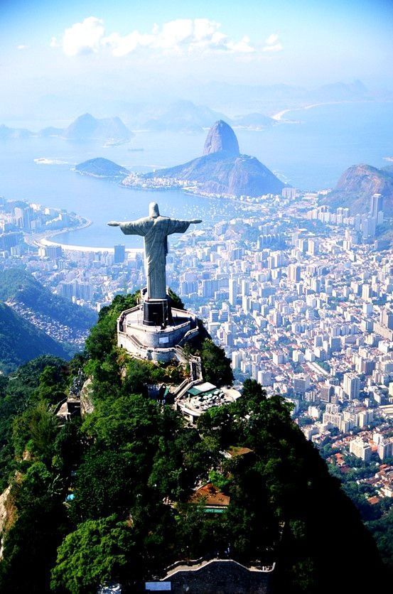 the statue of christ stands on top of a hill in rio, overlooking the city below