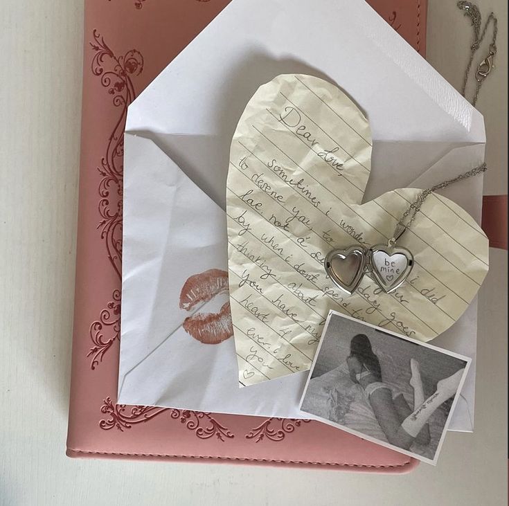 an open envelope with a heart and two photos