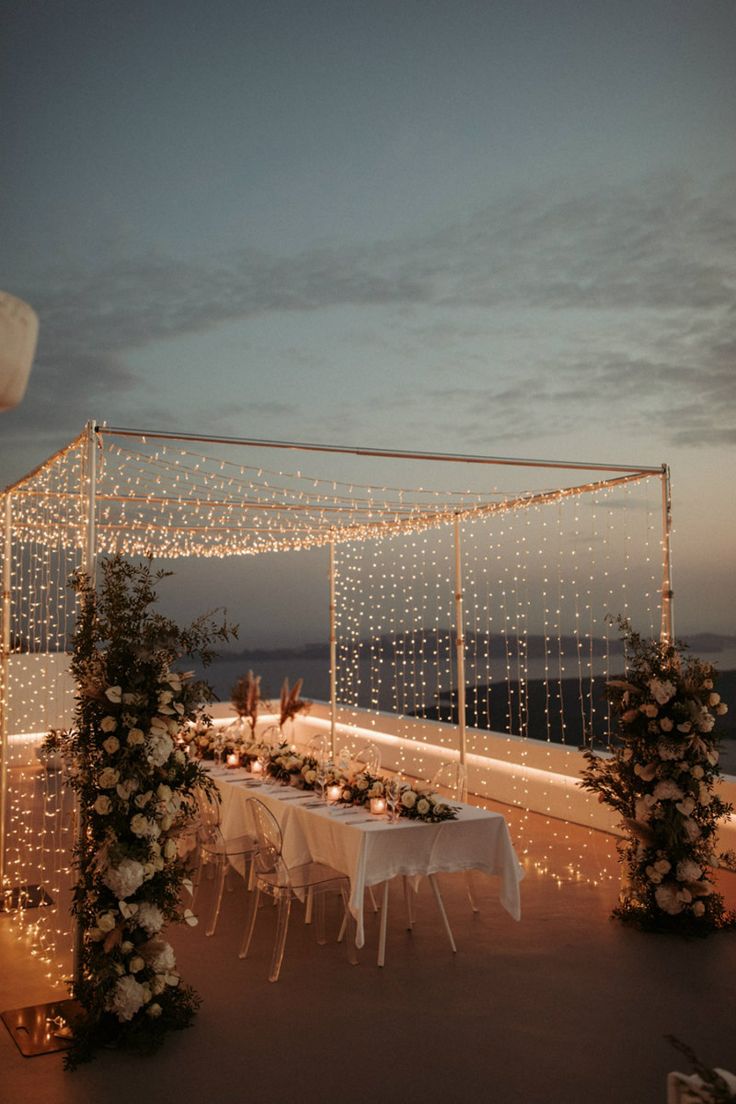 an outdoor wedding setup with lights and flowers