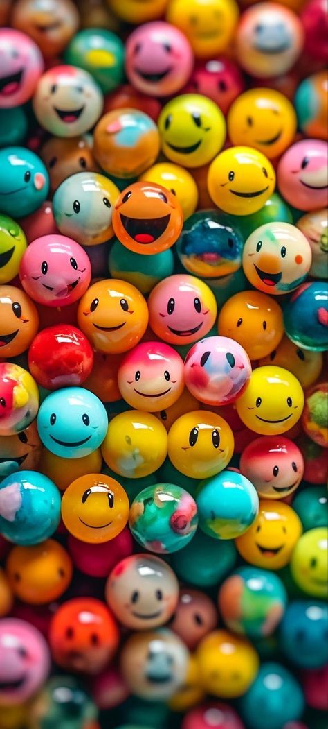 many different colored balls with smiley faces on them and one has a smiling face in the middle