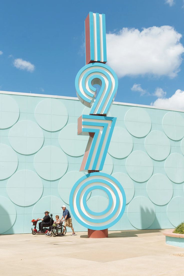 people are standing in front of a large sign with the number seven on it's side