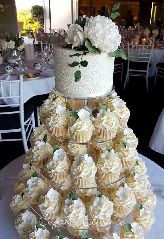 a wedding cake made out of cupcakes on a table