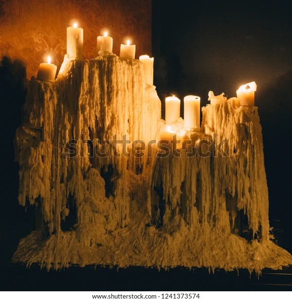 candles are lit in front of an ice - covered castle with icicles on it