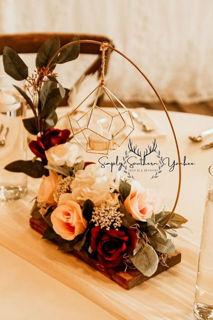 an arrangement of flowers and greenery on a table