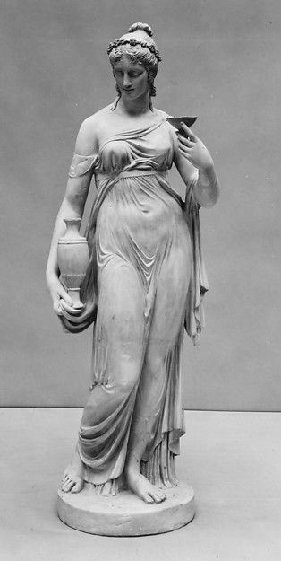 an antique statue of a woman holding a vase