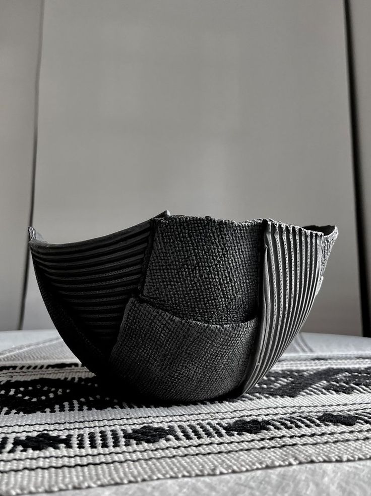 a black and white photo of a bowl on a tablecloth with an abstract design