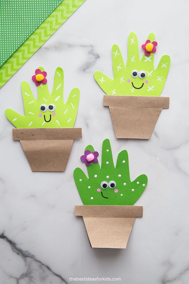 three paper cactus planters with flowers in them