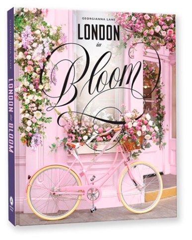 the london bloom book is on display in front of a pink building with flowers and greenery