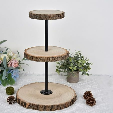 three tiered wooden cake stand with flowers in the background