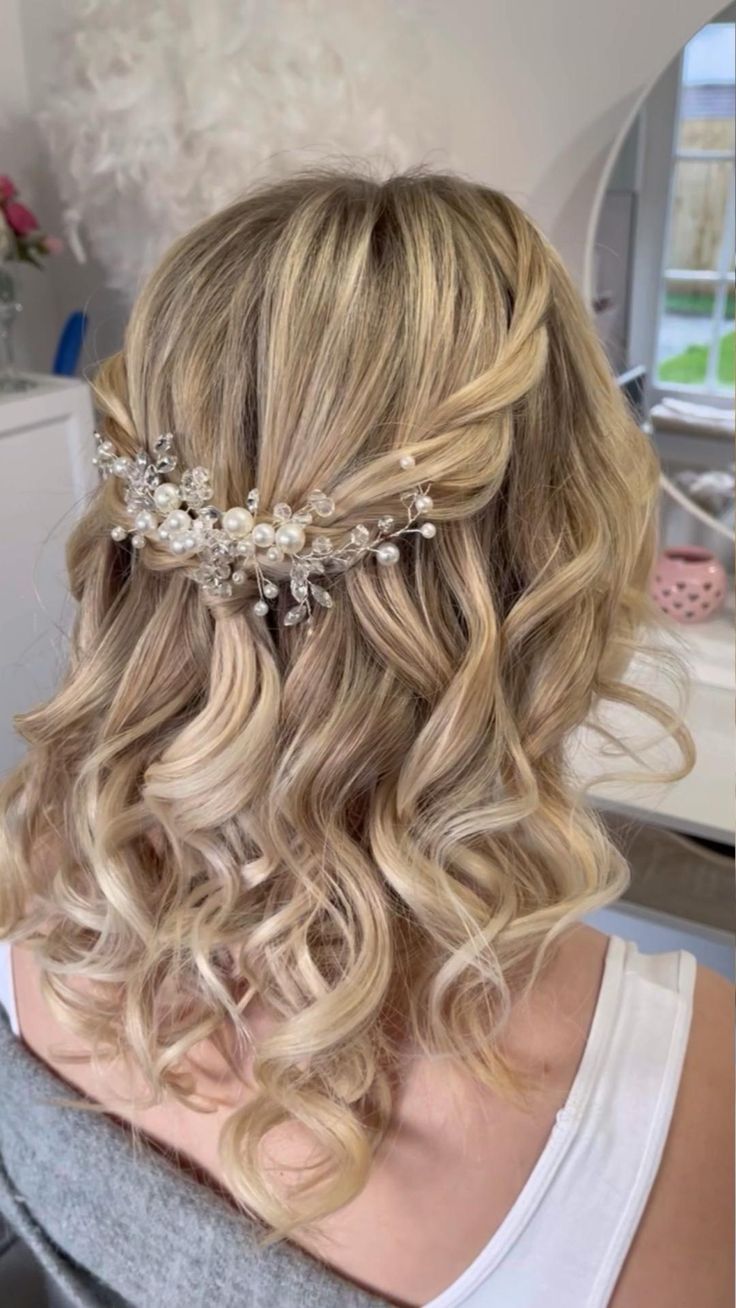 the back of a woman's head with blonde hair and flowers in her hair