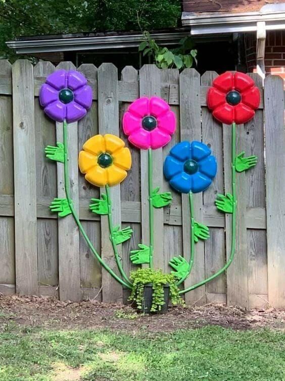 colorful flowers are painted on the side of a fence in front of a wooden fence