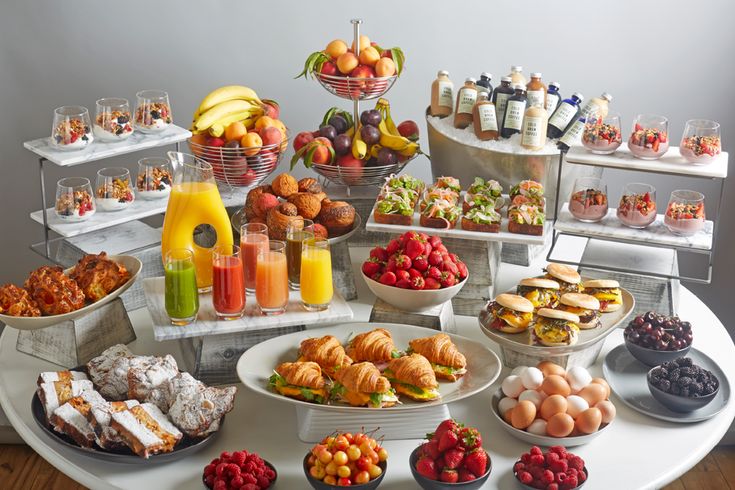 an assortment of food is displayed on a buffet table with plates and bowls full of food