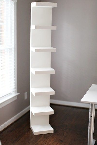 a tall white shelf sitting in the corner of a room