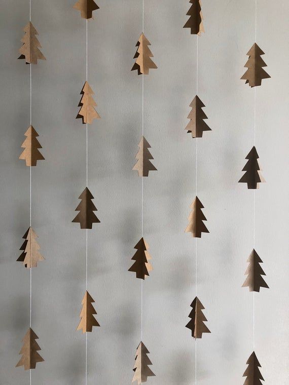 wooden christmas trees hanging from strings on a wall