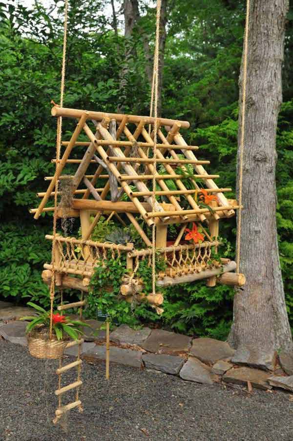 a tree house made out of wood sticks and some plants in the middle of it