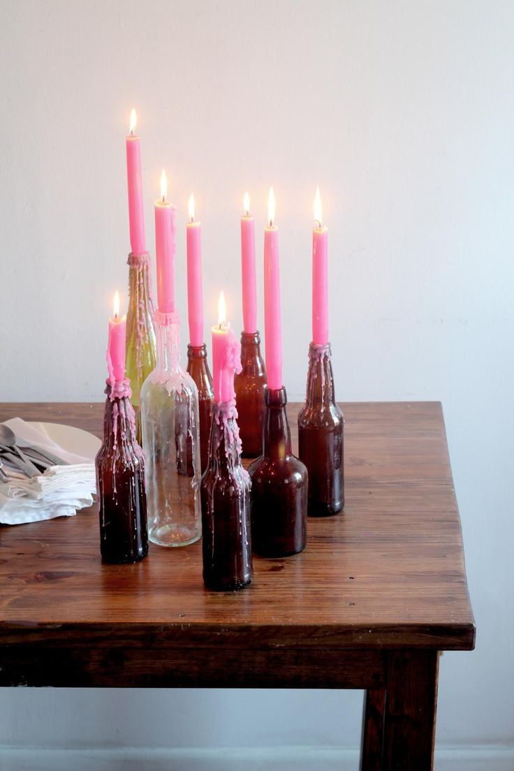 there are many bottles with candles in them on the table