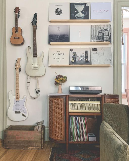 a living room with guitars on the wall and other musical instruments hanging on the wall