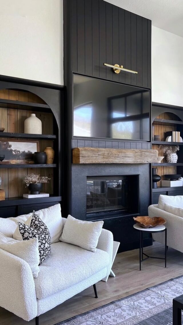 a living room with two white couches and a fireplace in the middle of it