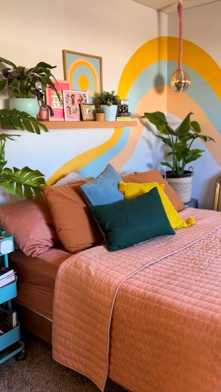 a bed sitting in a bedroom next to a wall with plants on top of it