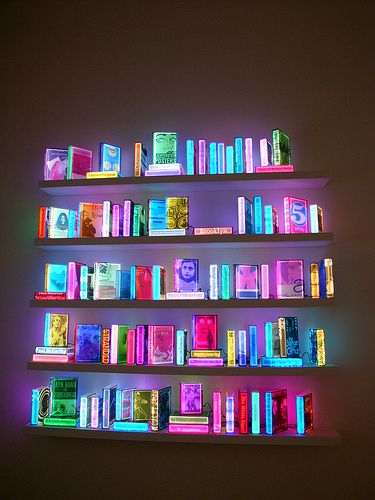a shelf filled with lots of books next to a wall
