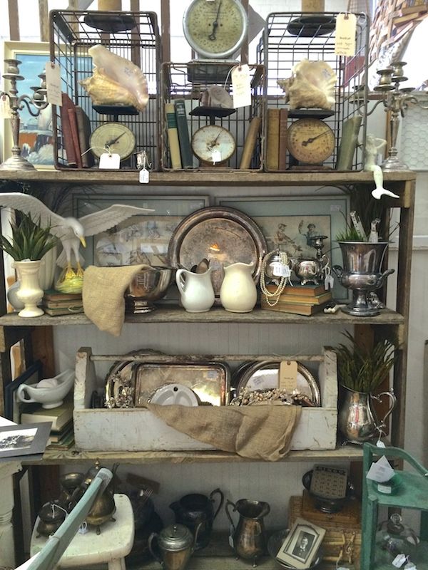 an assortment of antiques is displayed on shelves