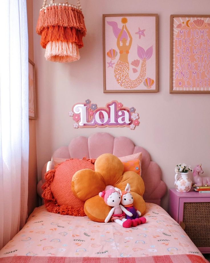 there is a stuffed animal on the bed in this girls'room with pink and orange decor