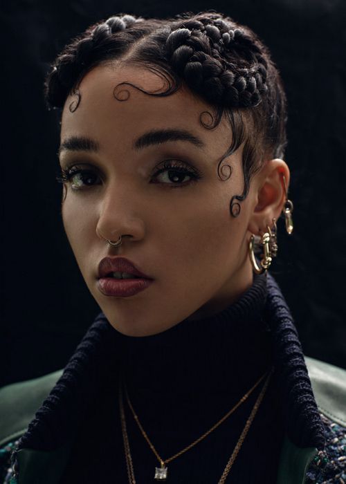 a woman with tattoos on her face and neck is looking at the camera while wearing gold necklaces