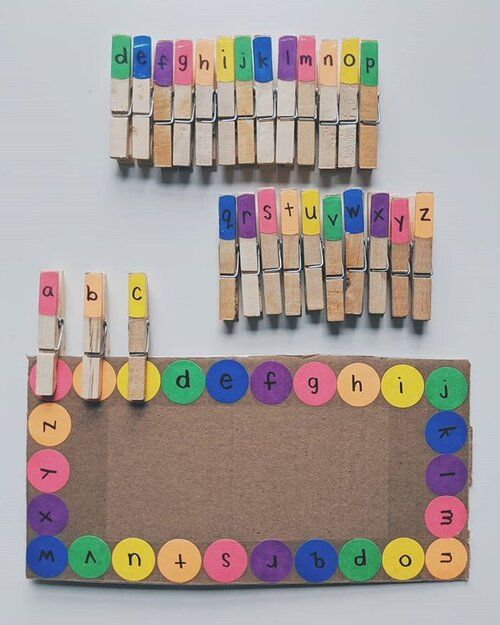 a bulletin board made out of clothes pegs with letters and numbers written on them