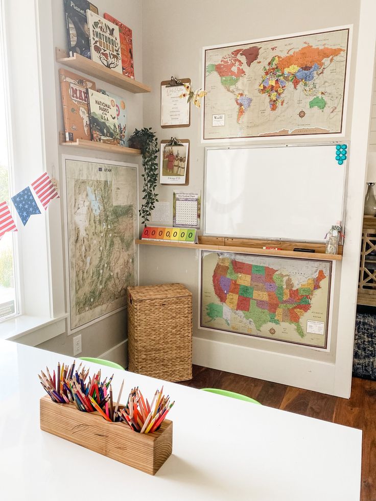 a white table topped with lots of colorful pencils next to a wall mounted map