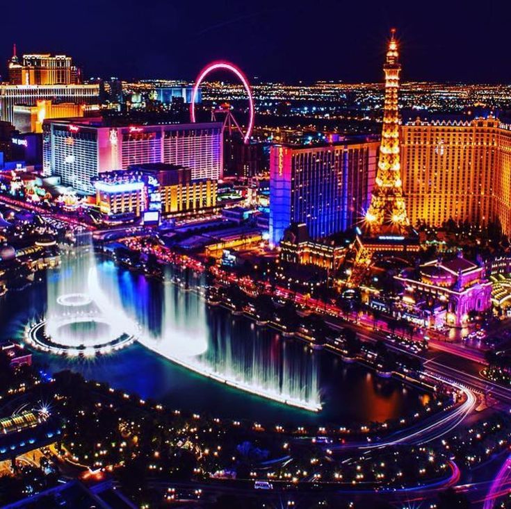 the las vegas strip is lit up at night with colorful lights and fountains in the water