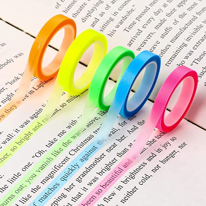 five different colored rings sitting on top of an open book