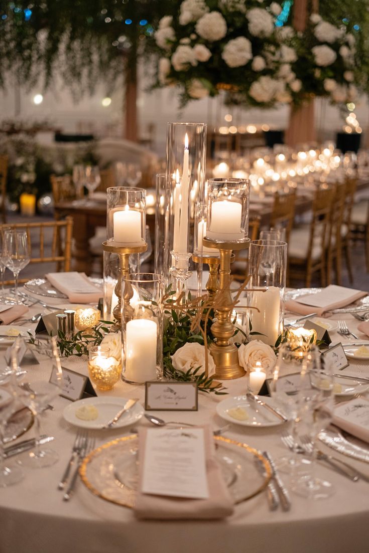 the table is set with candles, plates and place settings for an elegant wedding reception