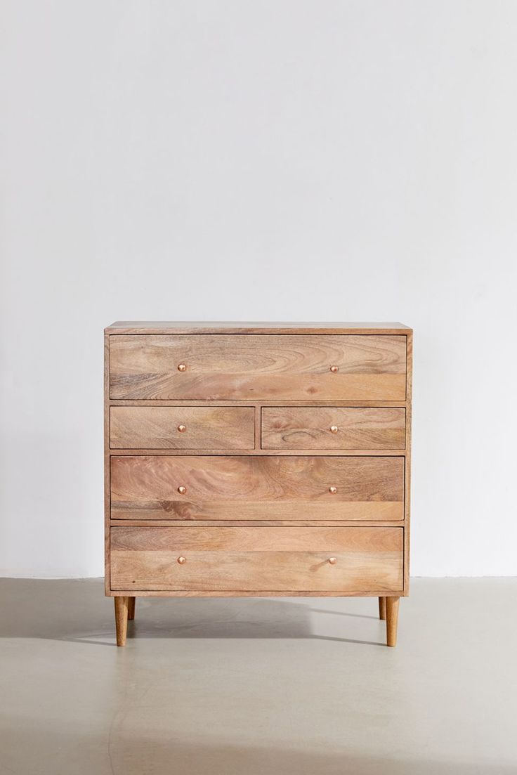 a wooden dresser sitting on top of a white floor