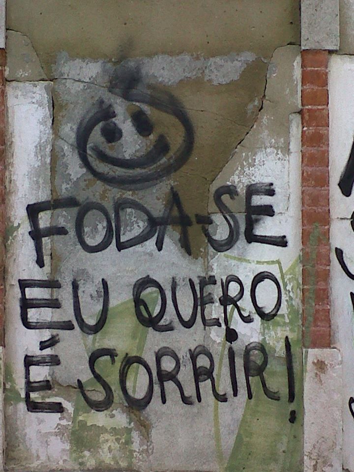 graffiti written on the side of a brick wall in spanish and english, along with another word that reads fodaise e u que que sorrio sob sorrir