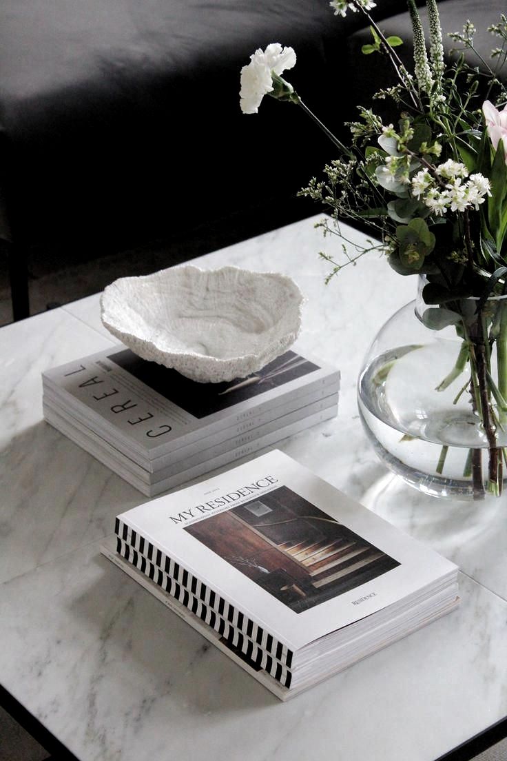 two books and a vase with flowers on a table