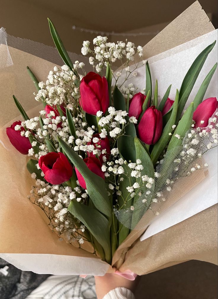 a bouquet of red tulips and baby's breath