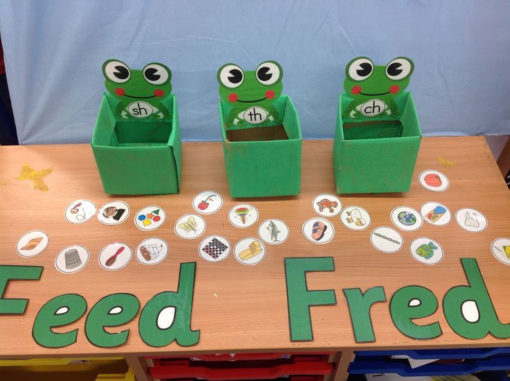 three frogs are sitting on top of a table with buttons and magnets in front of them