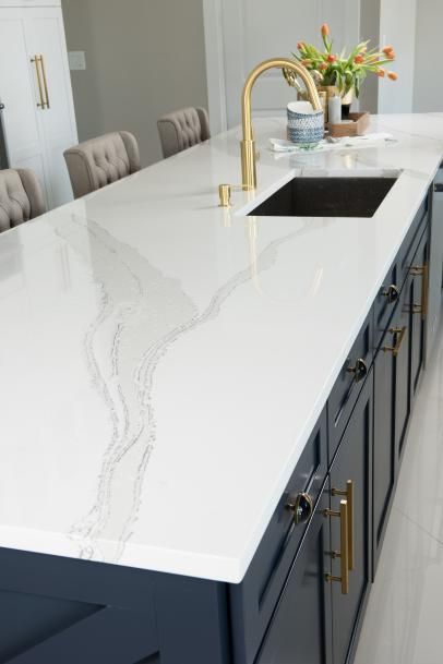 a kitchen counter with an island in the middle and gold faucet handles on it