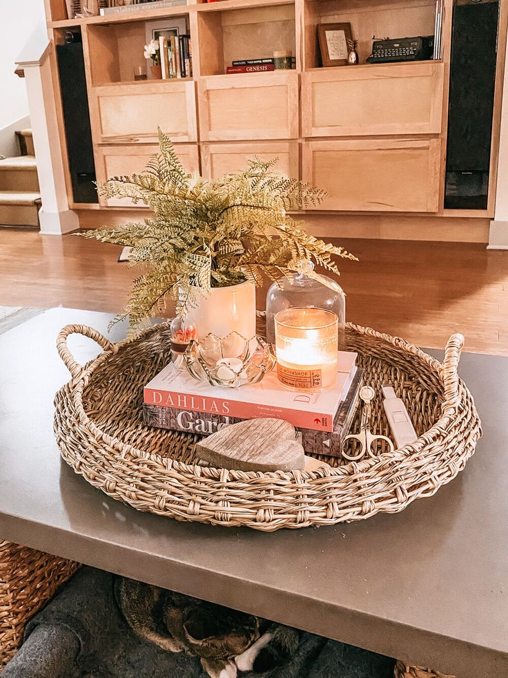 a wicker tray with books and candle on it