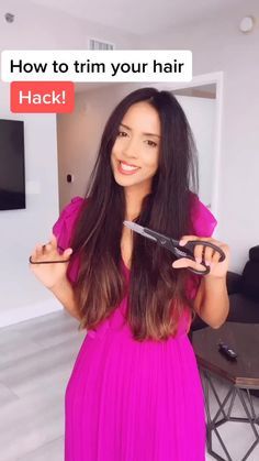 a woman in a pink dress holding a pair of scissors with the caption, how to trim your hair hack