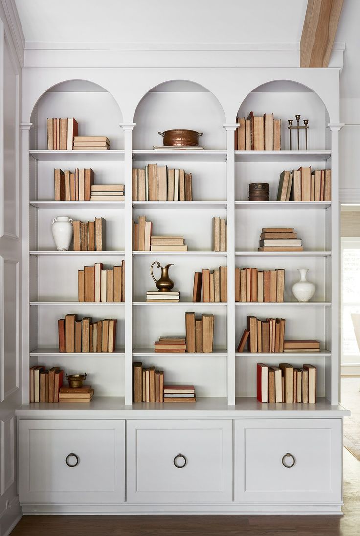 a white bookcase filled with lots of books