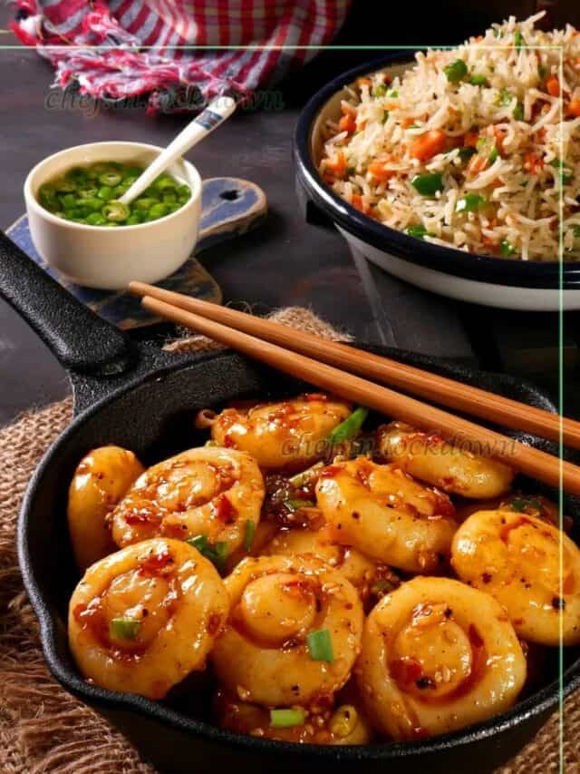 shrimp and rice in a skillet with chopsticks next to it on a table