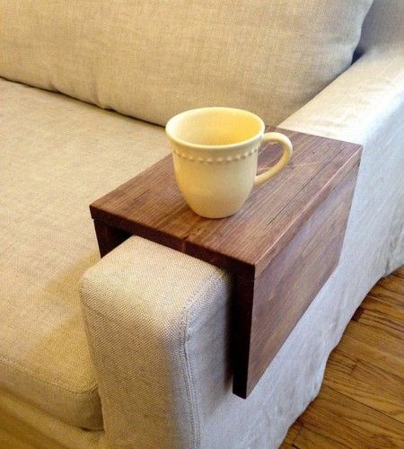 a coffee cup sitting on top of a wooden table next to a white couch in a living room