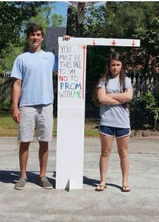 two people standing in front of a sign that says you must be there no to prom with me